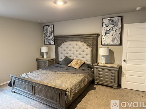 A bedroom with a large bed and two nightstands.