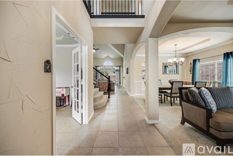 A spacious living room with a couch, chairs, and a balcony.