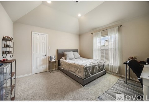 A bedroom with a large bed and a desk.