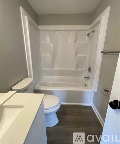 A white bathroom with a toilet, sink, and bathtub.