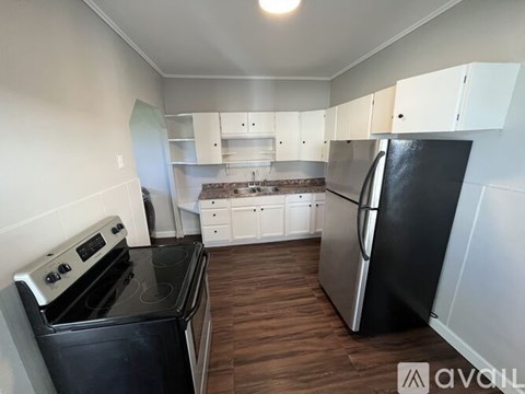 A kitchen with black appliances and white cabinets.
