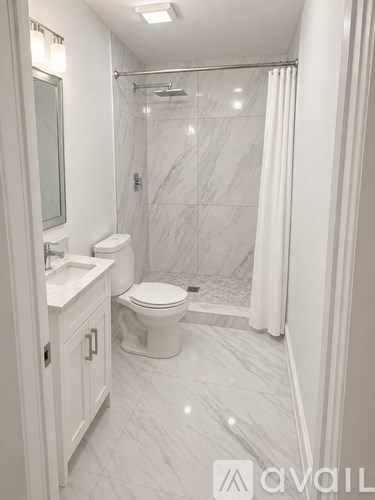 A bathroom with a toilet, sink, and shower.