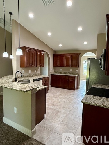 A kitchen with brown cabinets and a granite countertop.