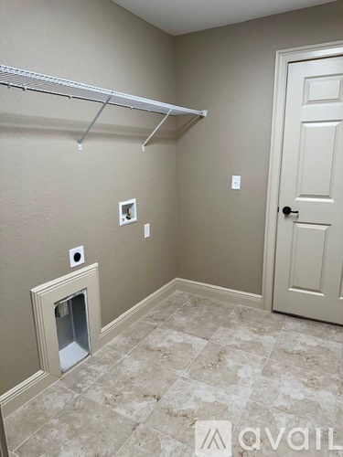 A white door is on the right side of a wall with a white shelf above it.
