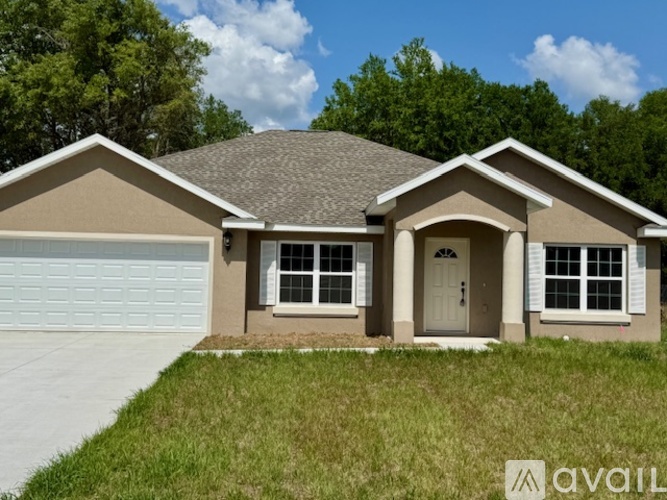 A house with a brown roof and a white garage door is for sale.