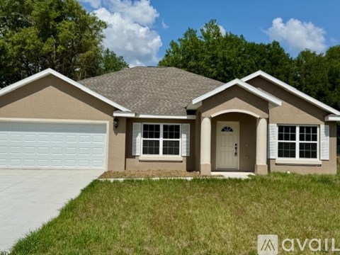 A house with a brown roof and a white garage door is for sale.