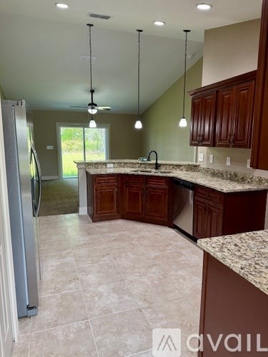 A kitchen with a refrigerator, cabinets, and a countertop.