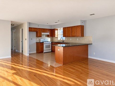 A kitchen with wooden cabinets and a countertop is available for rent.