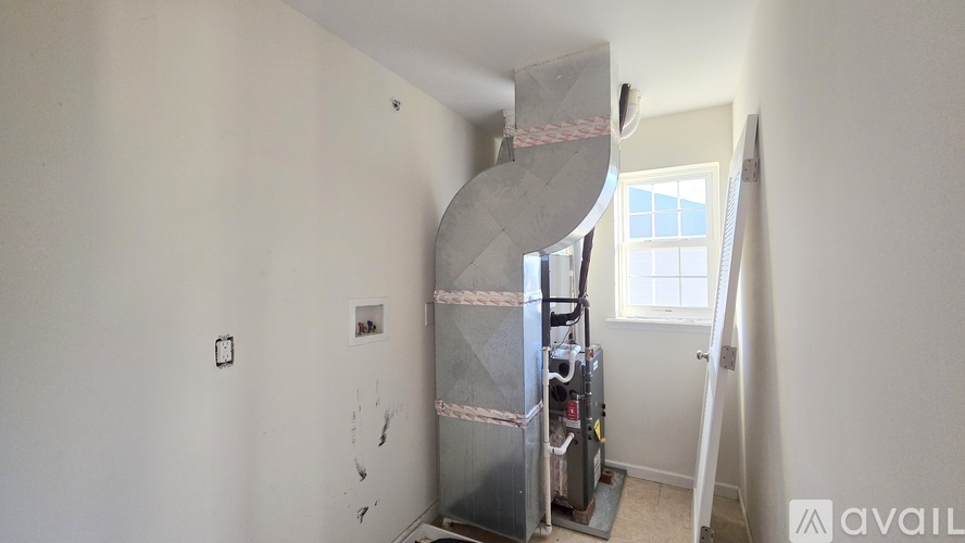 A room with a spiral staircase and a window.