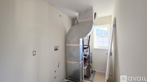 A room with a spiral staircase and a window.