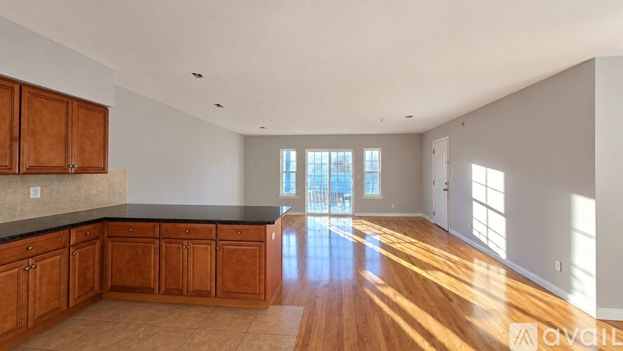 A spacious kitchen with wooden cabinets and a black countertop.