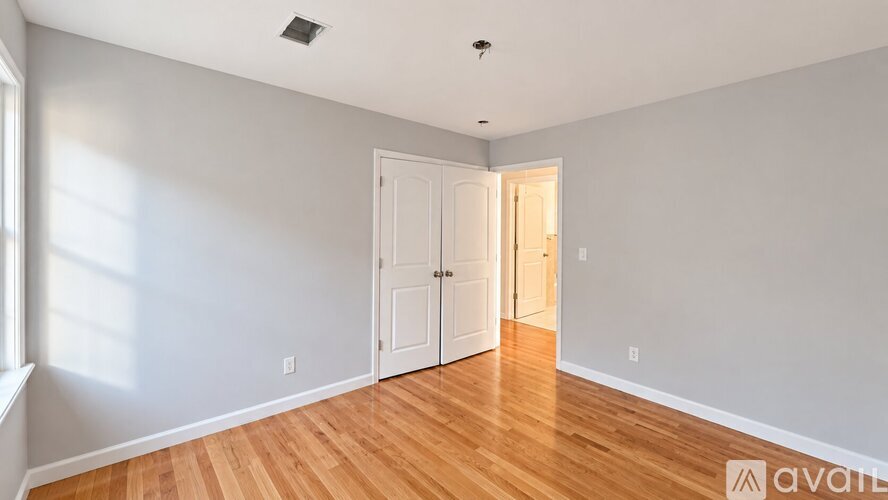 A room with wooden floors and two doors.