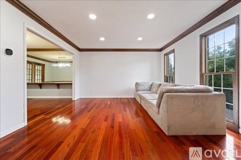 A living room with a couch and a wooden floor.
