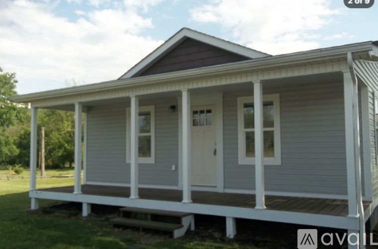 A small house with a porch is available for sale.
