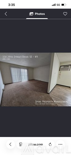 A room with a carpeted floor and a window with blinds.