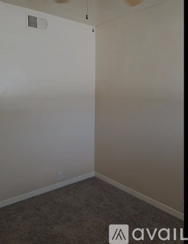 A room with a carpeted floor and a white wall.