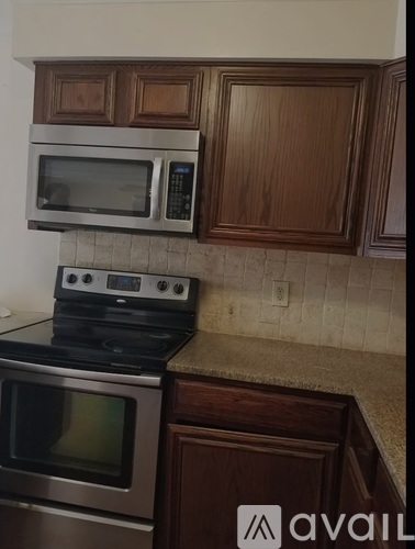 A kitchen with a stove top oven and microwave above it.