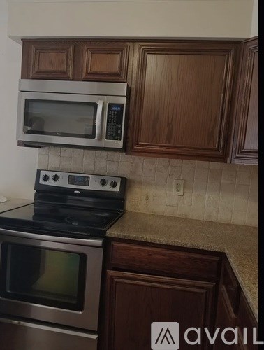A kitchen with a stove top oven and microwave above it.