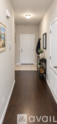 A hallway with a white door and a brown floor.