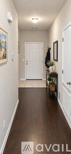 A hallway with a white door and a brown floor.