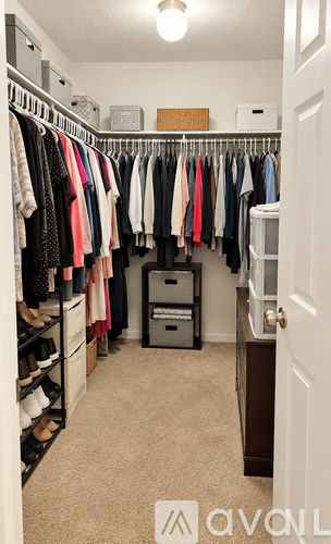 A white door is on the right side of a room with a carpeted floor.