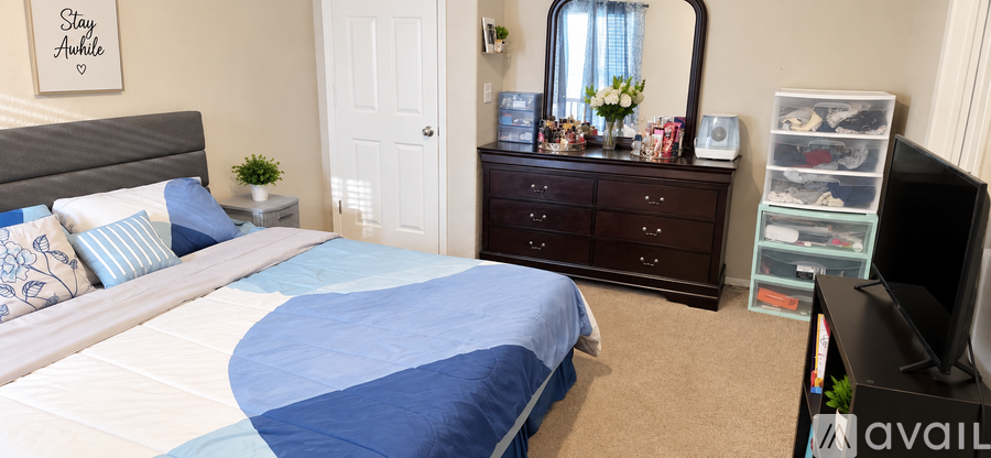 A bedroom with a bed, dresser, and mirror.