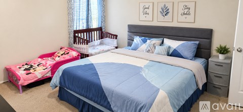 A bedroom with a blue and white bed and a pink bench.