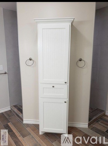 A room with wooden flooring and white walls.