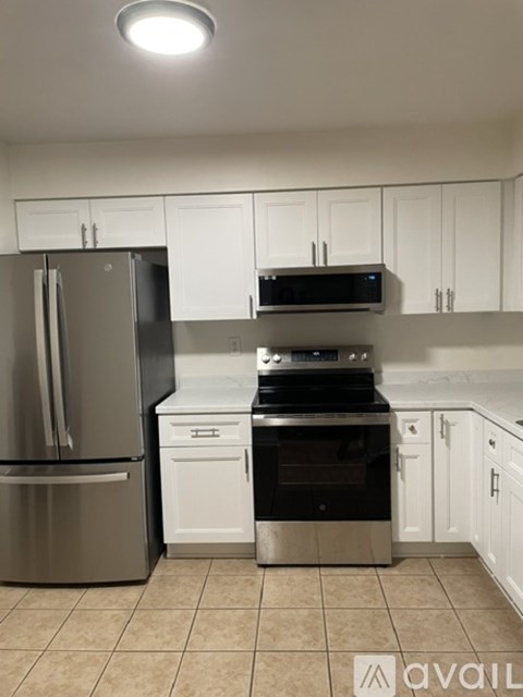 A kitchen with a refrigerator, oven, and microwave.