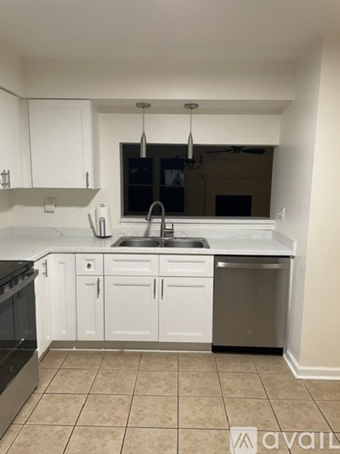 A kitchen with white cabinets and a black oven.