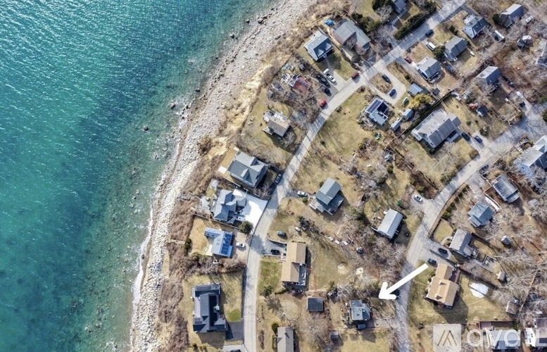 A bird's eye view of a coastal residential area with houses and roads.