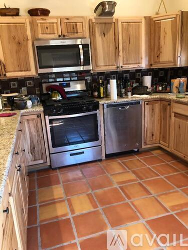 A kitchen with wooden cabinets and tile flooring.
