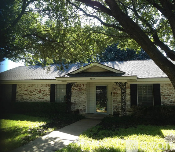 A house with a front porch and a tree in front of it.
