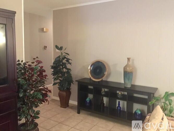 A living room with a wooden shelf and a mirror.