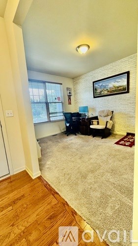 A living room with a couch, chair, and a painting on the wall.