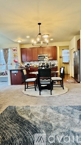A kitchen with a dining table and chairs in the middle.