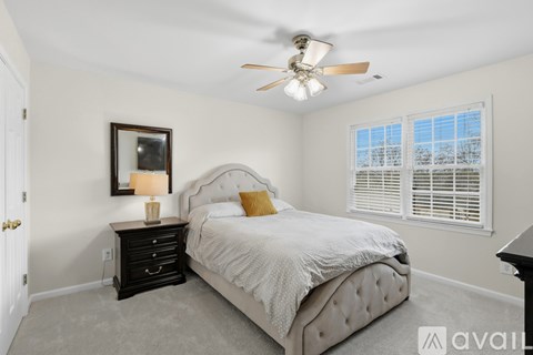 A bedroom with a bed, dresser, and window.