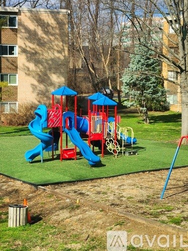 A playground with a blue slide and red and blue play structures.