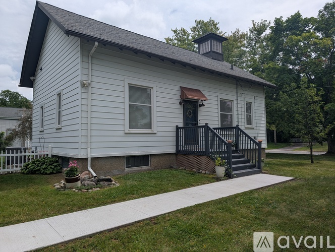 A house with a porch and a white picket fence.