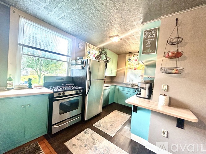 A kitchen with a refrigerator, stove, and sink.