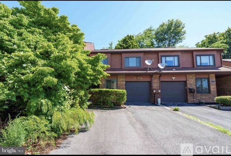 A house with a driveway and garage doors.