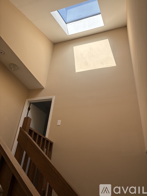 A skylight in a room with a wooden staircase.
