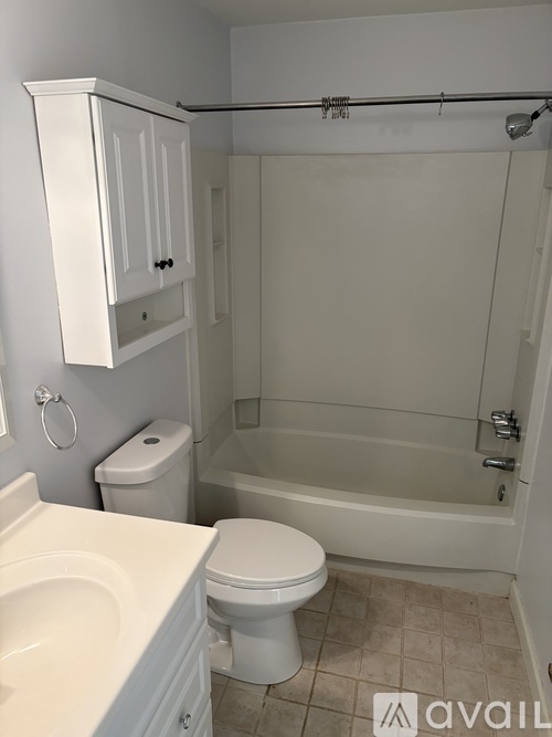 A white bathroom with a toilet, sink, and bathtub.