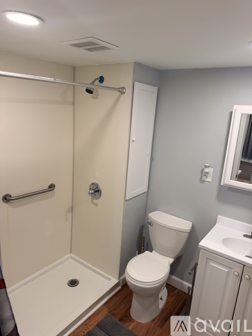 A white toilet in a bathroom with a white shower curtain.
