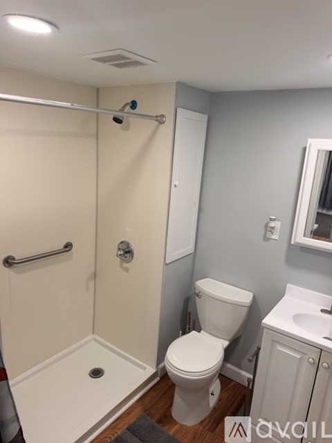 A white toilet in a bathroom with a white shower curtain.
