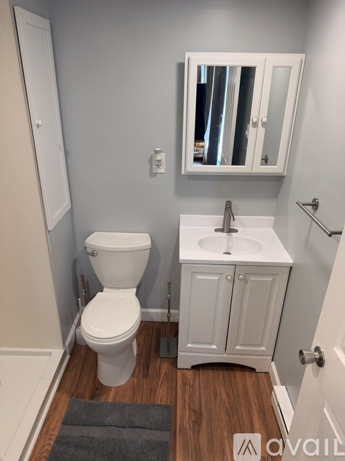 A white toilet and sink in a small bathroom.