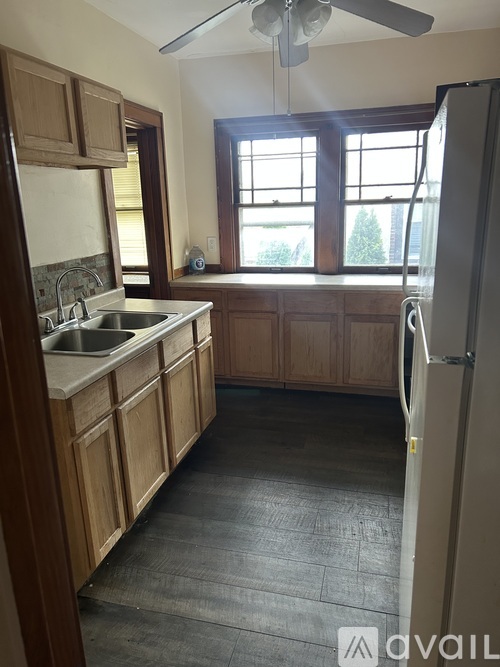 A kitchen with wooden cabinets and a window.