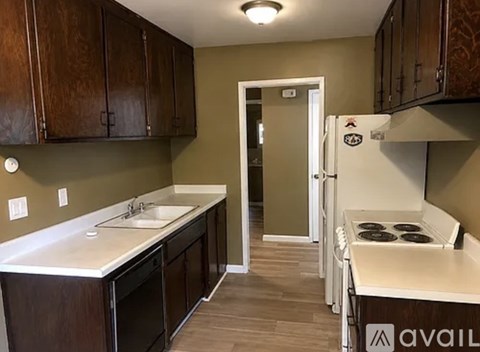 A kitchen with brown cabinets and a white fridge.