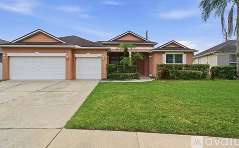 A house with a brown roof and two garages.