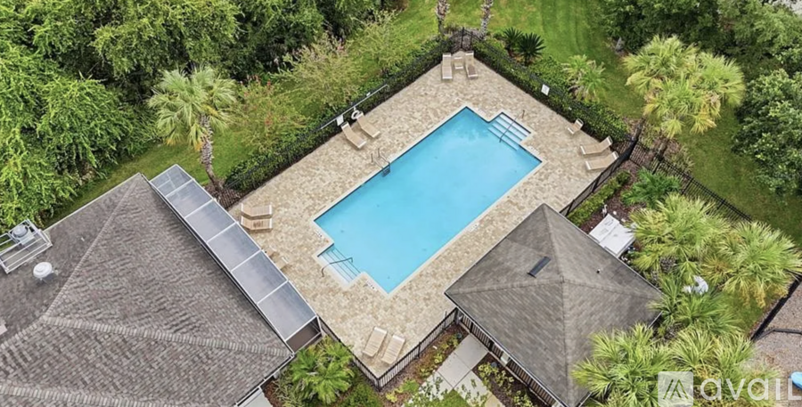 A swimming pool surrounded by a stone wall and palm trees.